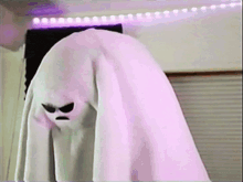 a ghost with an angry face is hanging on a purple light