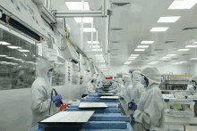 workers in a clean room with a sign that says ' safety first '