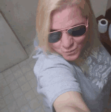 a woman wearing sunglasses and a shirt that says ' i love you ' on it takes a selfie