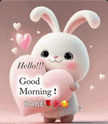 a stuffed bunny is holding a pink heart and says good morning babe