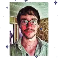 a man with glasses and a beard has a red spot on his face