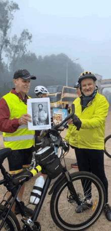 a man in a yellow vest is holding a picture of a man in a helmet