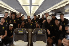 a group of soccer players pose for a picture on a plane with a seat that says " official home of soccer " on it