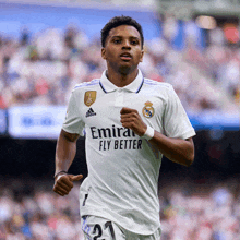 a soccer player wearing a white jersey with emirates fly better on the front