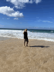 a person standing on a beach with waves crashing on the sand