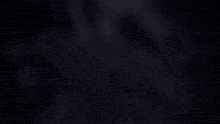 a blurry picture of a woman sitting on a swing in the dark .