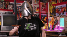 a man wearing a knight 's helmet and holding a sword is wearing a shirt that says event 2020