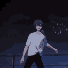 a man in a white shirt is standing in front of a fireworks display at night .