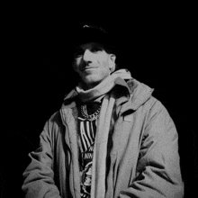 a black and white photo of a man wearing a nike jacket and a shirt that says nin