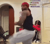 a man in a black tank top and white shorts dancing