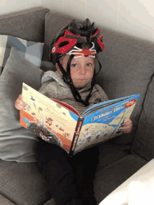 a young boy wearing a helmet is reading a book called foxtrot rider