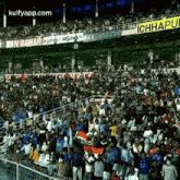 a large crowd of people are watching a soccer game in a stadium with a banner that says ichhapli on it .