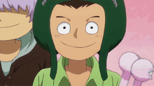 a boy wearing a green hat and a green shirt is smiling