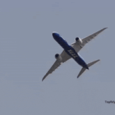 a boeing x222 plane is flying through a clear blue sky
