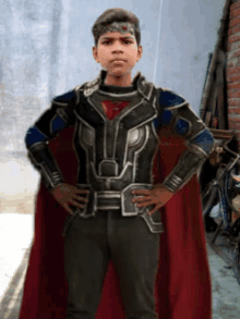 a young boy in a superhero costume is standing with his hands on his hips