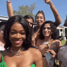 a group of women are posing for a picture together and one of them is wearing a green top .