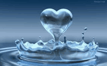 a heart shaped drop of water is coming out of a splash of water .