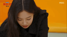 a woman is smiling in front of a screen that says mbc on it