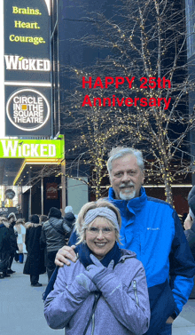 a man and woman are posing in front of a sign that says wicked