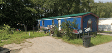 a blue mobile home with a green roof has a satellite dish on the side