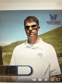 a man wearing sunglasses stands in front of a screen that says west coast conference on it