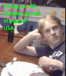 a young man sits at a table with the words da jeg var 30 written on it