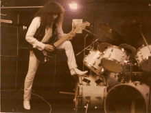 a man plays a guitar in front of a marshall amp