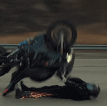 a person laying on the ground with a motorcycle behind them