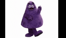 a purple mcdonald 's mascot is standing on a white background and waving .