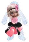 a doll is sitting on top of a pink heart shaped object .