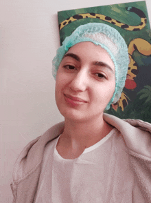 a woman wearing a surgical cap is smiling in front of a painting of a monkey