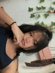 a girl is taking a picture of herself in front of a pink purse