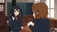 two anime girls are standing in a room and one is holding a plate of food