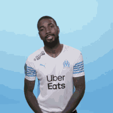 a man wearing a white shirt that says uber eats on the front