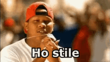 a man wearing a red hat and a white shirt is saying ho stile .