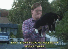 a man holding a cat with the words that 's one fucking nice kitty right there above him