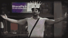 a man with a crown on his head stands in front of a sign that says bharatpe