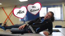 a man laying on a table with two hearts that say alex and my beloved above him