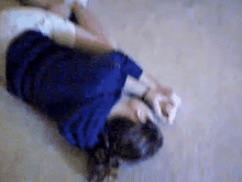 a woman in a blue dress is laying on the floor with her hands tied .