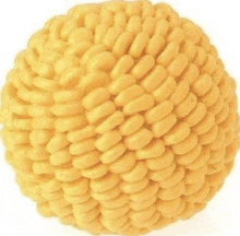 a close up of a yellow ball with a knitted pattern on a white background .