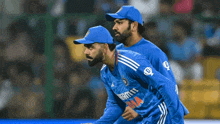 two cricket players wearing blue uniforms with the letter d on the front