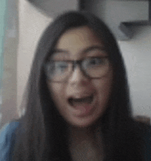 a young woman wearing glasses is making a funny face .