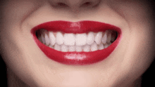 a close up of a woman 's smile with red lipstick on her lips