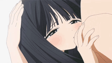 a girl with black hair is kissing a man 's neck