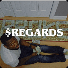 a man is laying on the floor surrounded by money and the word regards is visible above him