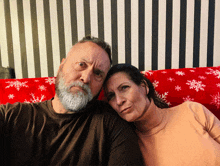 a man and a woman are sitting on a red couch