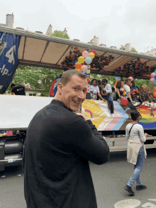 a man stands in front of a truck with the letter a on the side