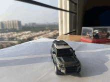 a toy car with a roof rack sits on a table