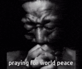 a man is praying for world peace with his hands folded .