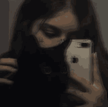 a girl is taking a selfie with her cell phone .